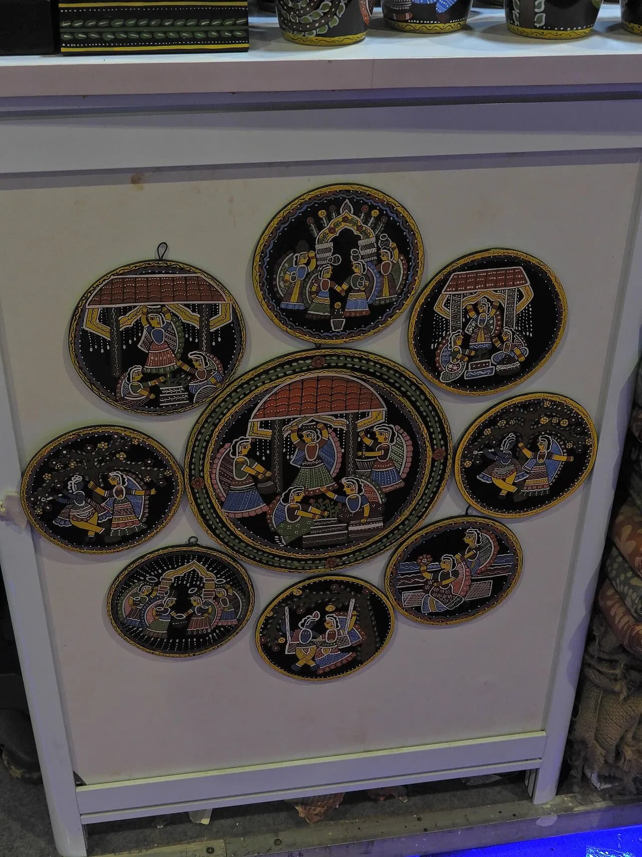 Hand-painted decorative plates displayed at a stall at the India International Trade Fair 2023