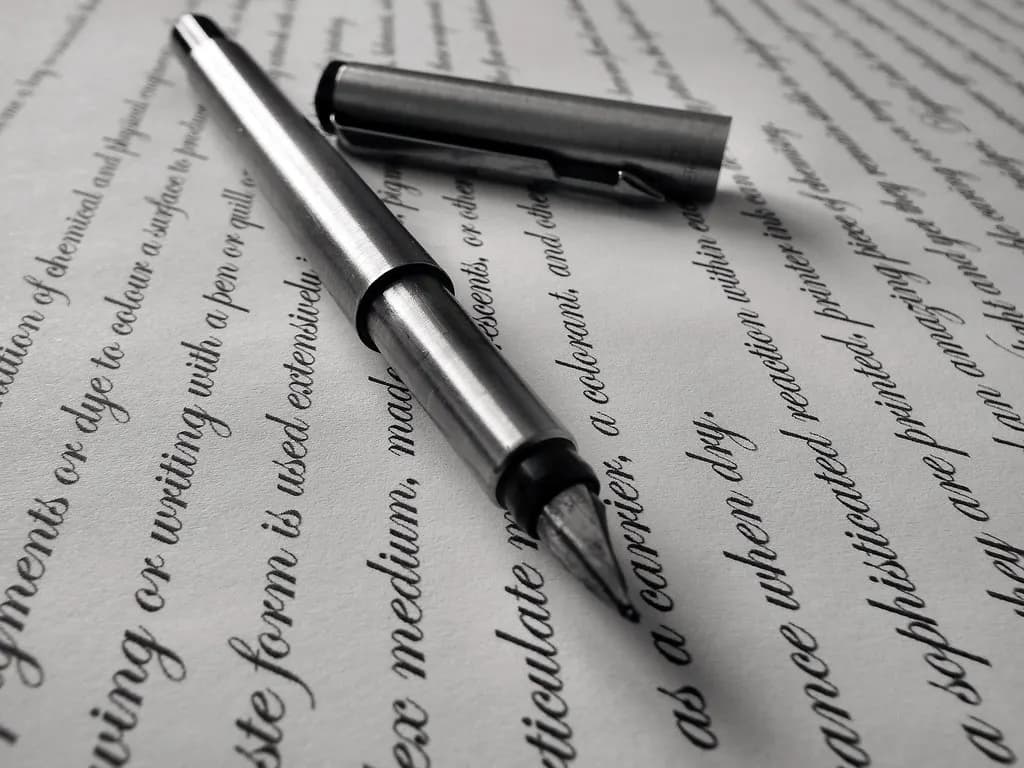 A silver fountain pen lying on a printed page of text