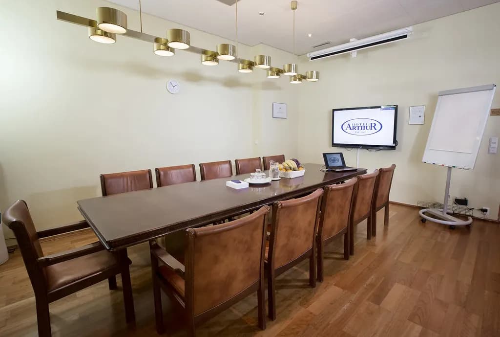 An empty boardroom with a long table and chairs ready for a meeting