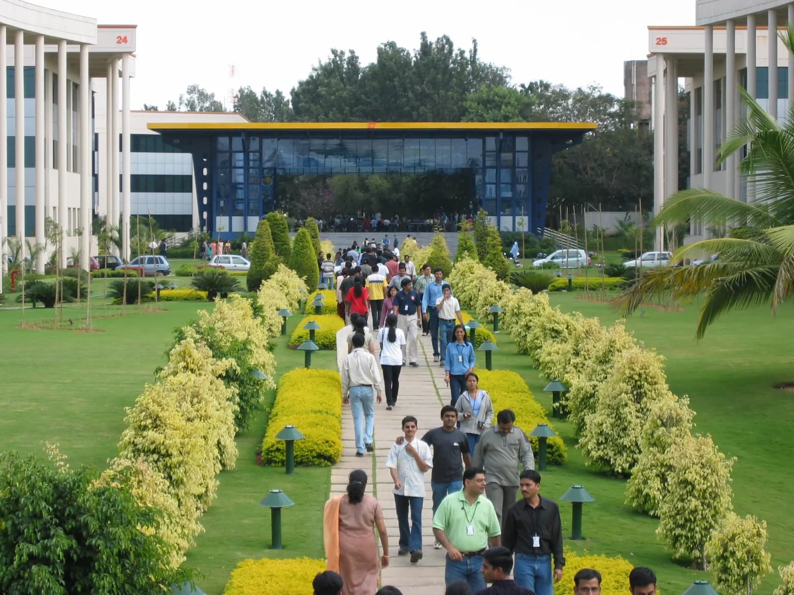 Salaried employees walking along a garden path on a tech campus in Electronic City, Bengaluru