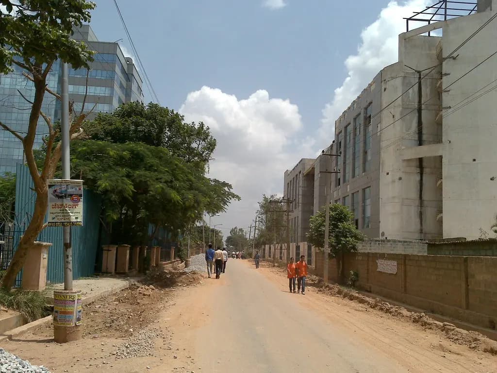 Office blocks along a road near International Tech Park, Whitefield, Bengaluru, with office workers walking