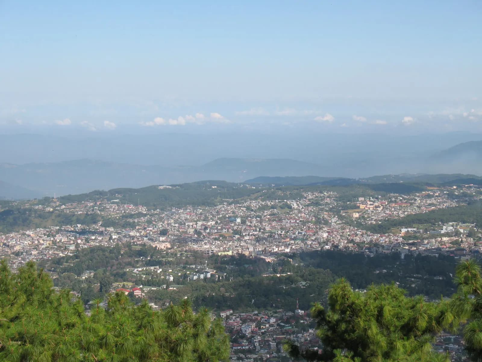 Panoramic view of Shillong spread across green hills under a hazy sky