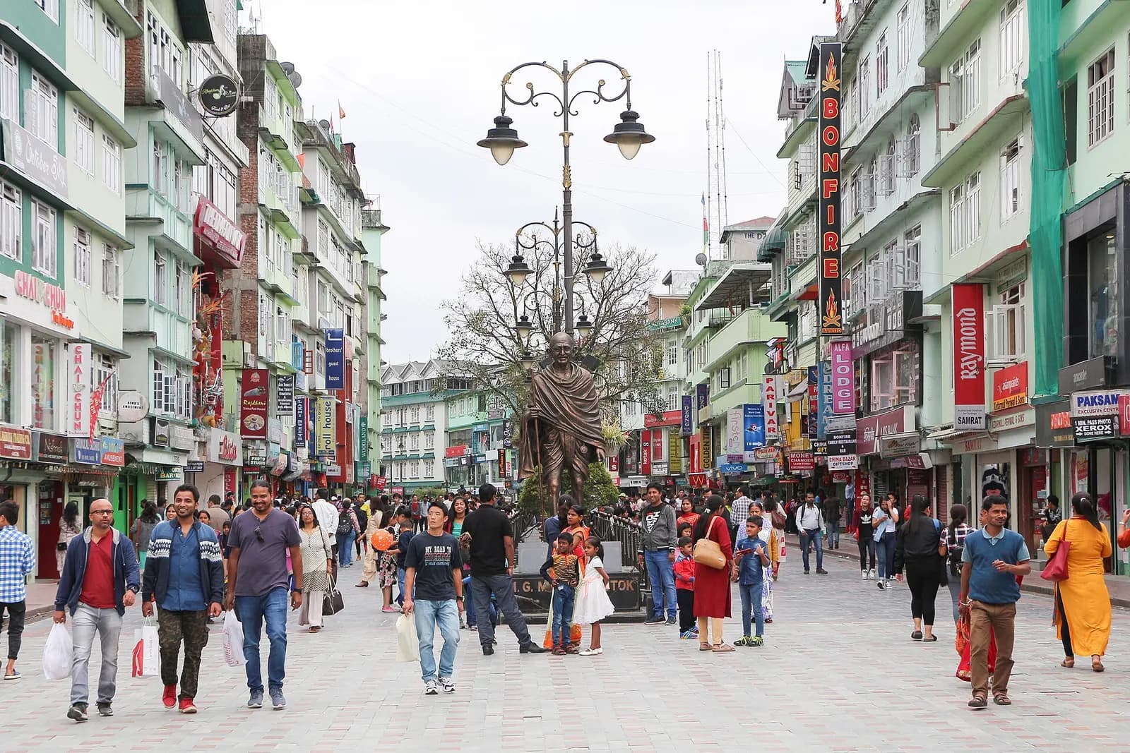 Pedestrians walking along the paved M.G. Marg shopping street lined with multi-storey shops in Gangtok, Sikkim