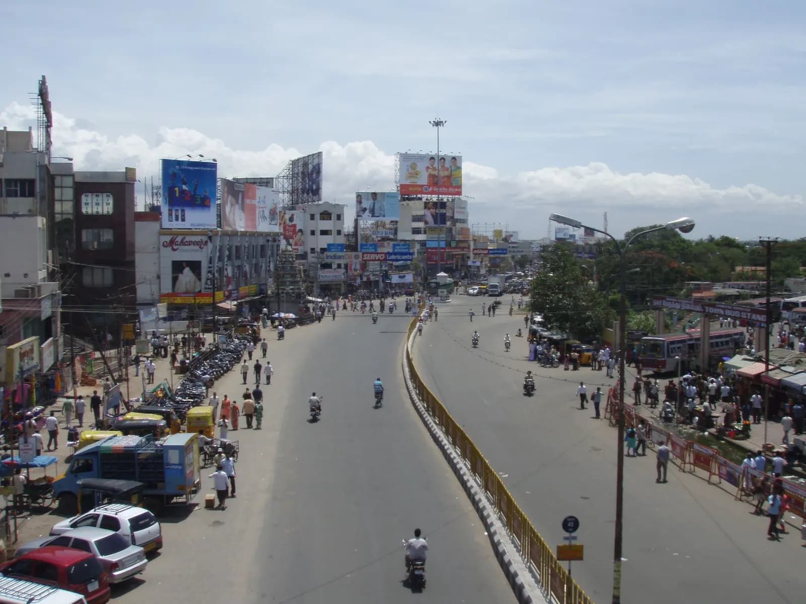 A main road in Coimbatore lined with shops and commercial buildings