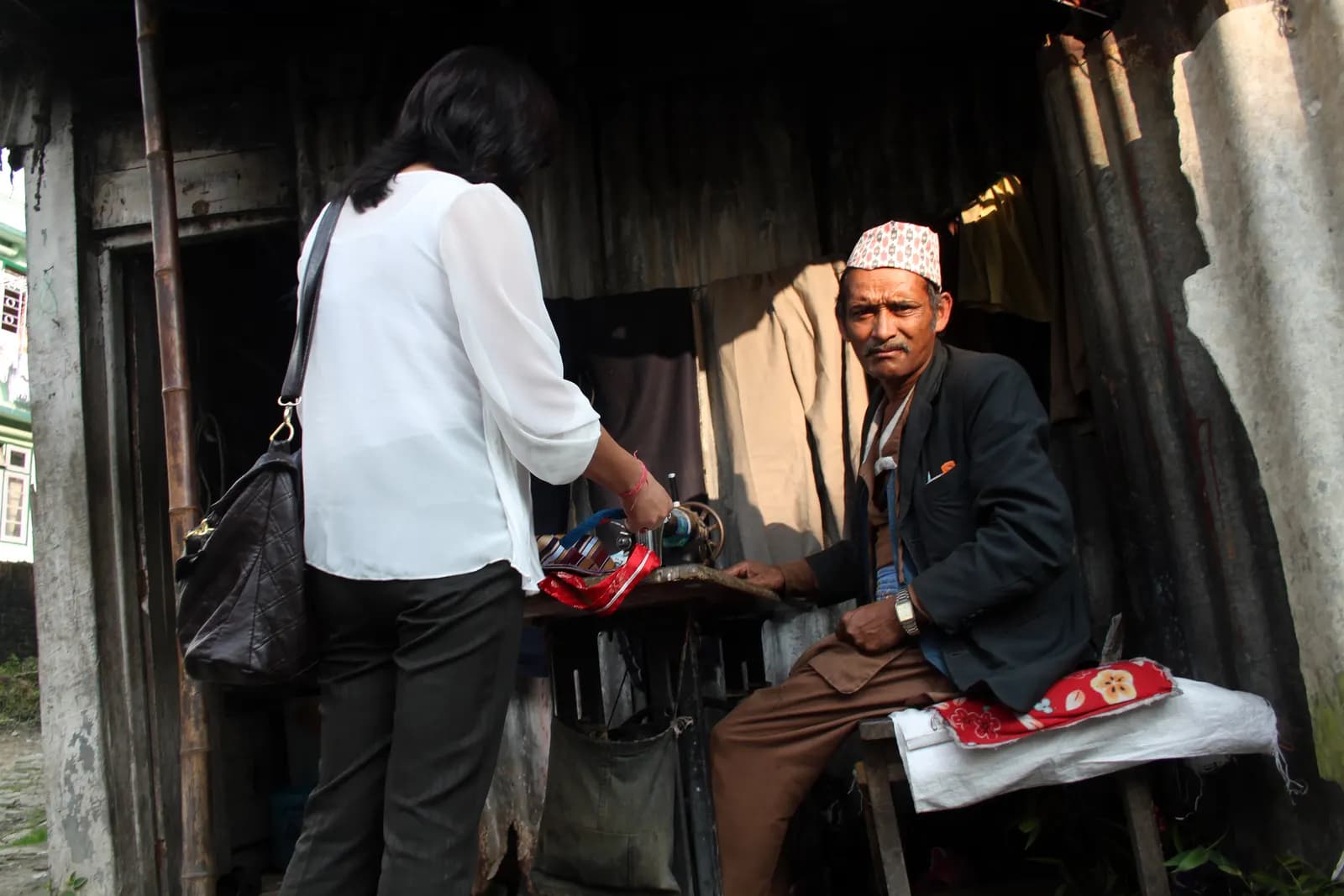 A tailor working at his sewing machine in a small open-fronted shop in Gangtok, Sikkim