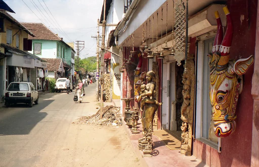 Handicraft and antique shops with carved wooden figures along a street in Fort Kochi