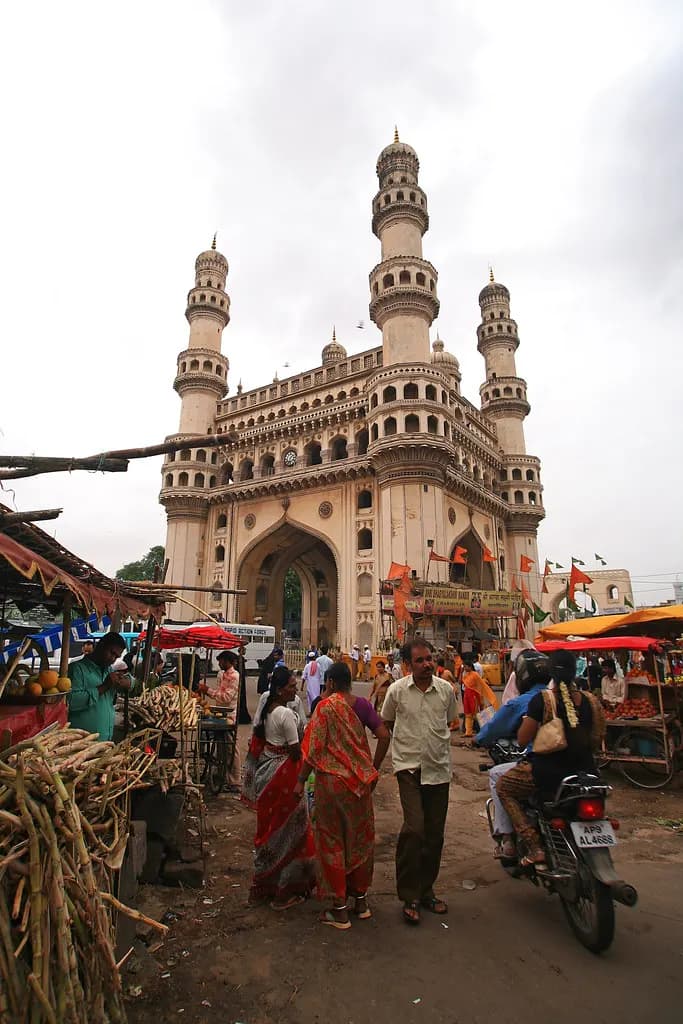 Fruit and sugarcane stalls and shoppers in the street market in front of the Charminar, Hyderabad