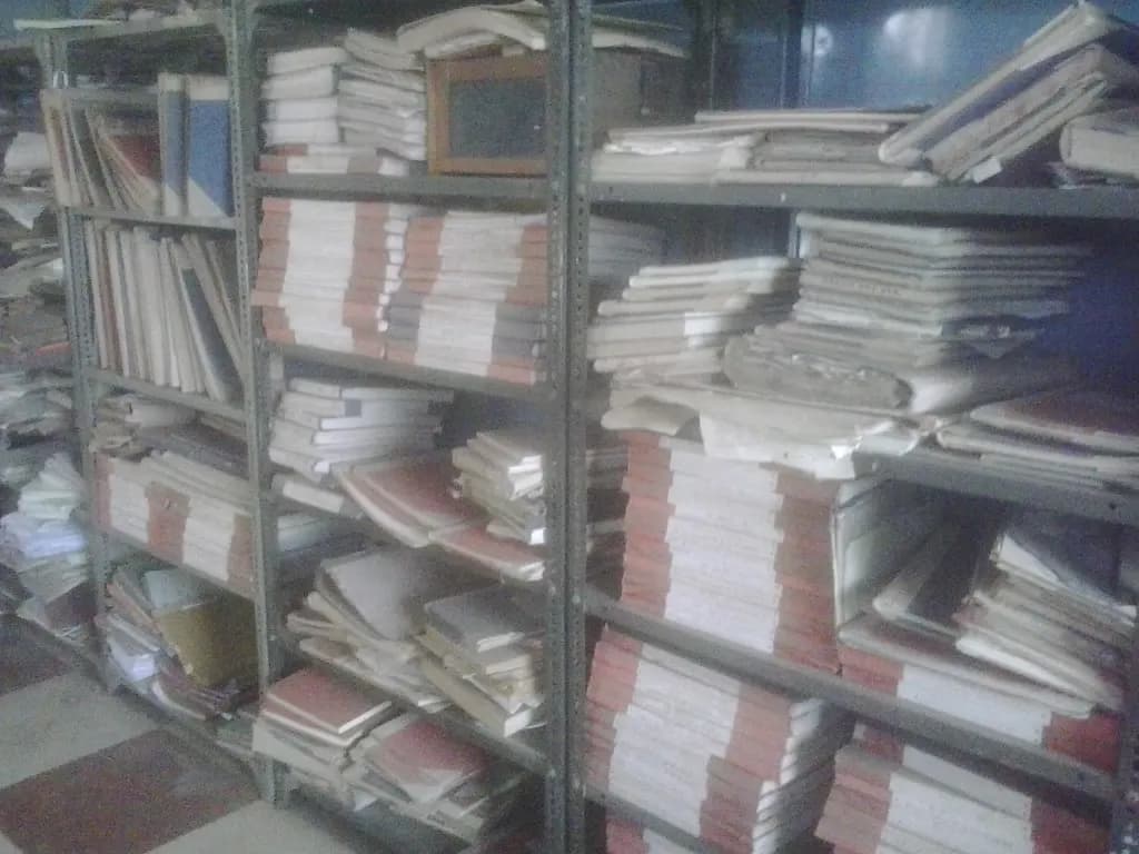 Steel shelves in an Indian government office stacked with bundled paper files and registers