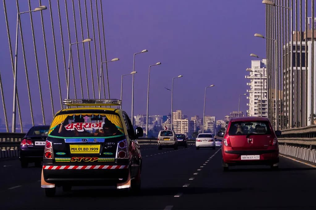 Rear of a Mumbai taxi with a yellow commercial number plate on the Bandra–Worli Sea Link
