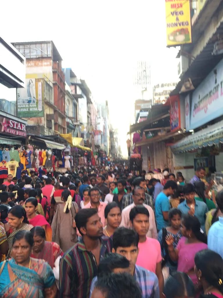 A packed shopping street in T. Nagar, Chennai, lined with textile and sweet shops