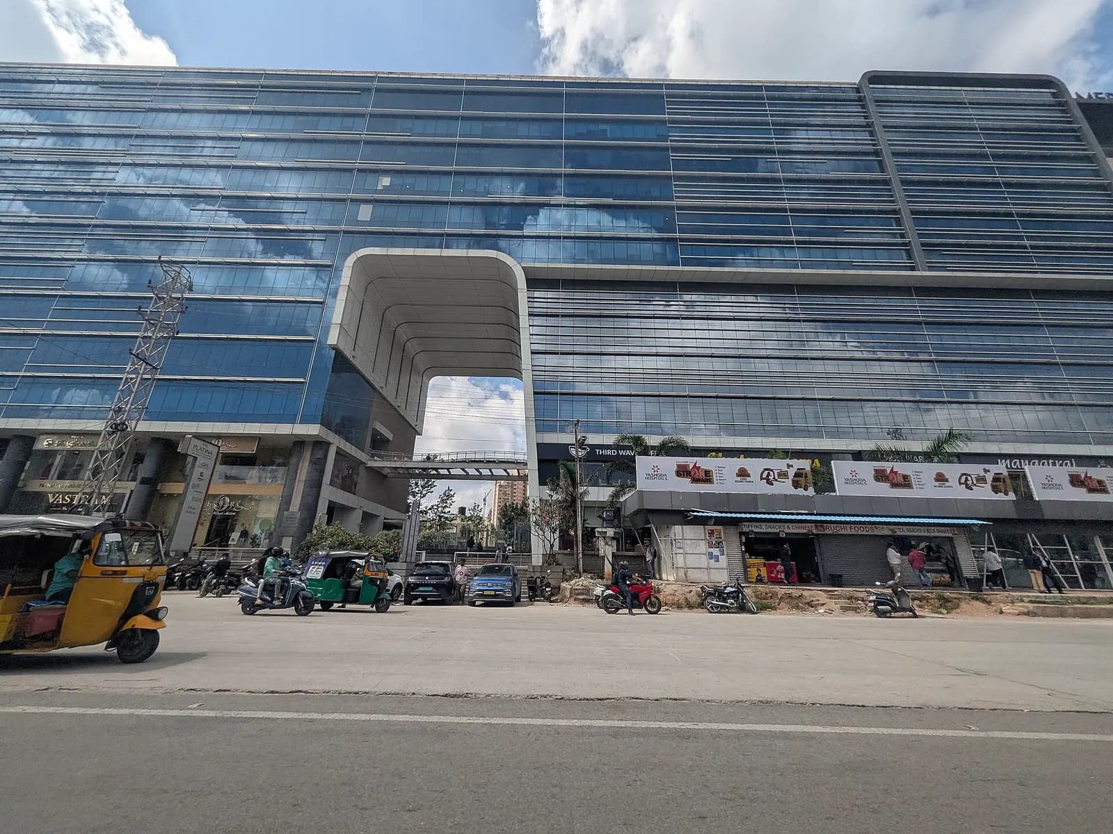 Glass-fronted commercial building beside a wide multi-lane road in Hyderabad