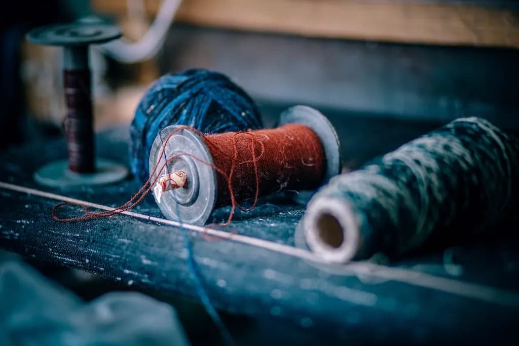 Spools of wool and thread on a workbench in a small textile workshop in Old Manali