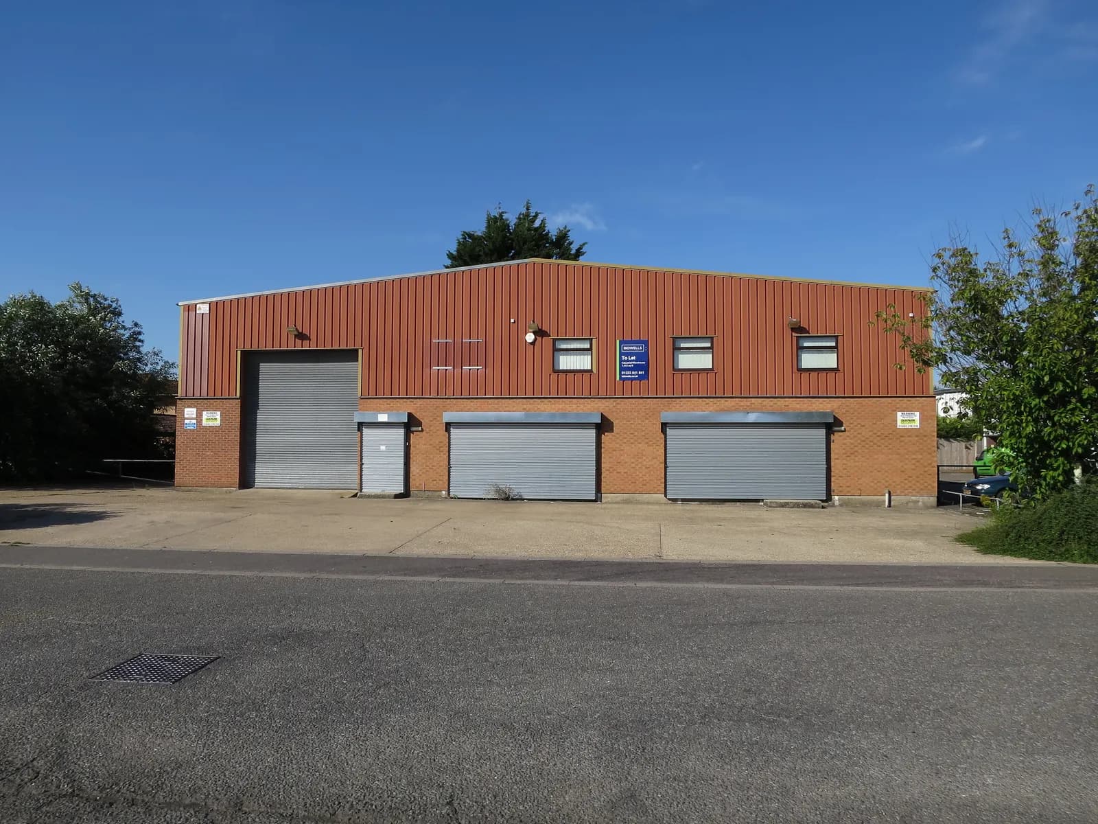 A vacant industrial unit with a To Let board on an English trading estate