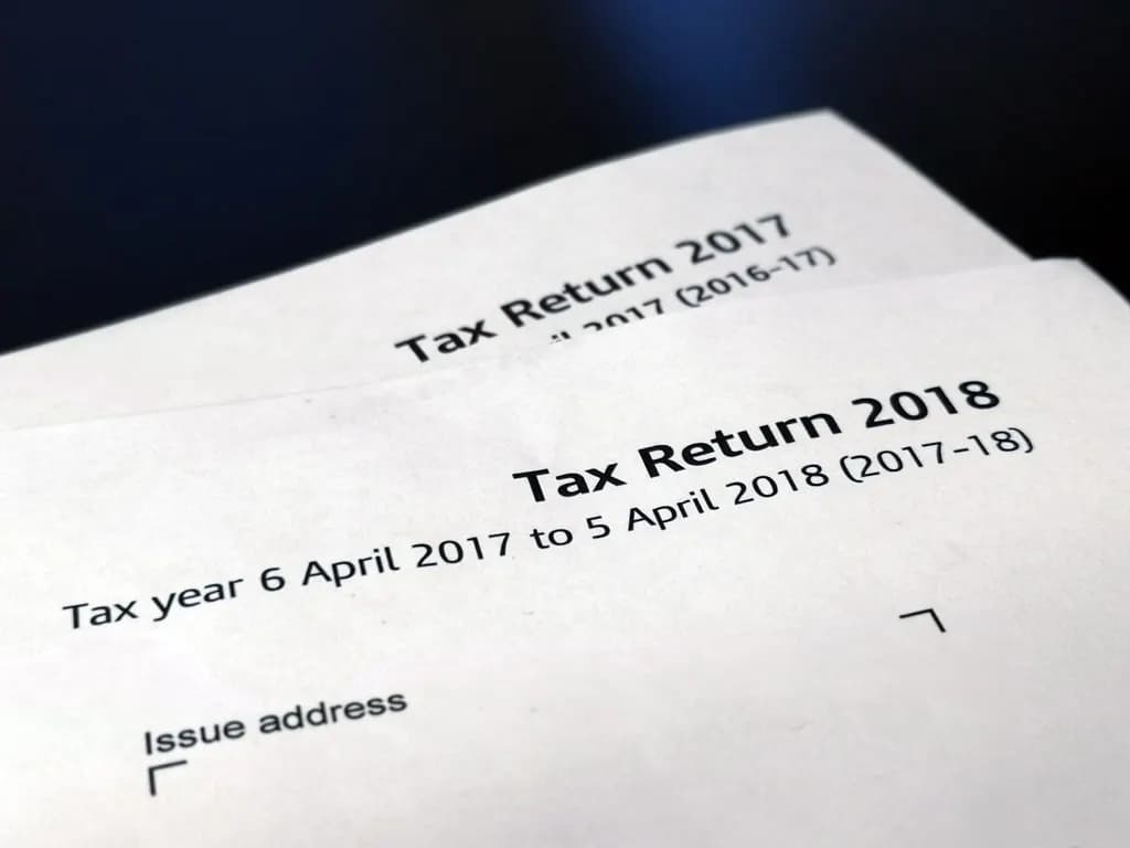 Two printed HMRC Self Assessment tax return forms showing the tax years 2016-17 and 2017-18