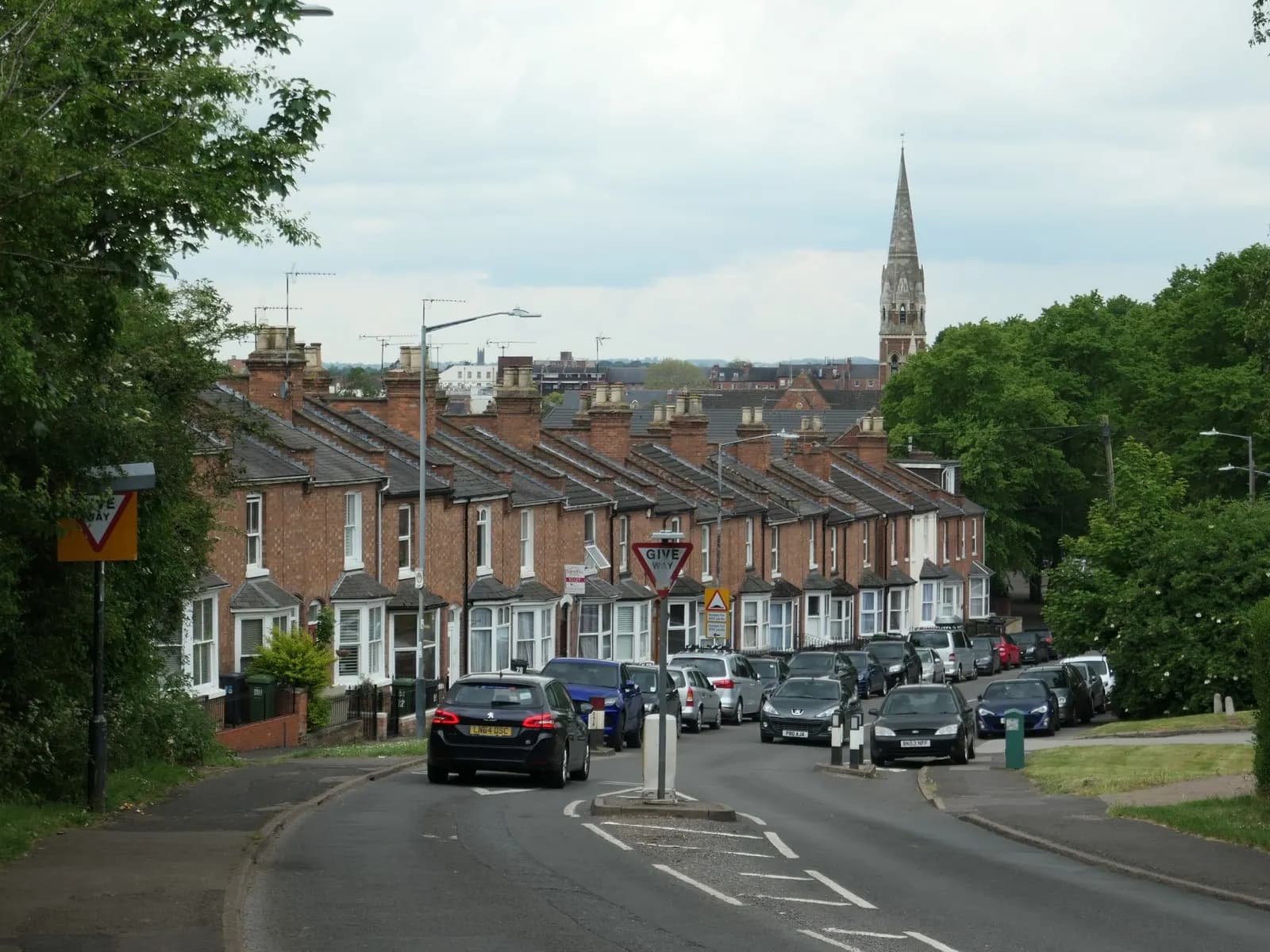 A street of Victorian red-brick terraced houses in an English town