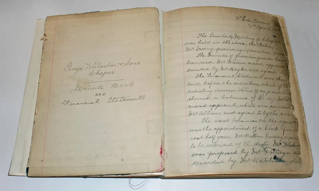 An open handwritten minute book from 1913 recording a meeting