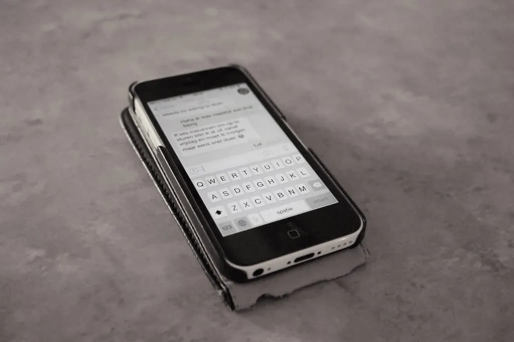 Smartphone lying on a table showing a text message conversation