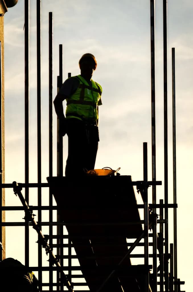 A builder working on scaffolding on a London building site
