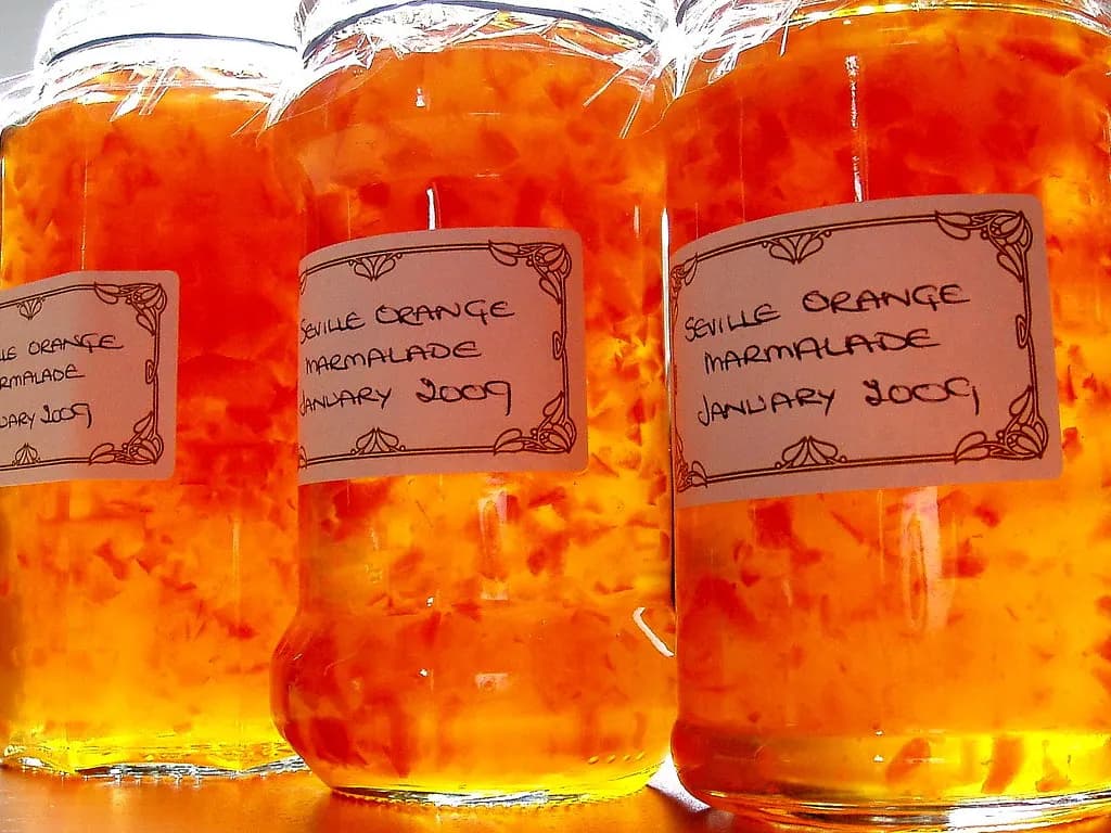 Jars of Seville orange marmalade with handwritten labels showing the name and month made