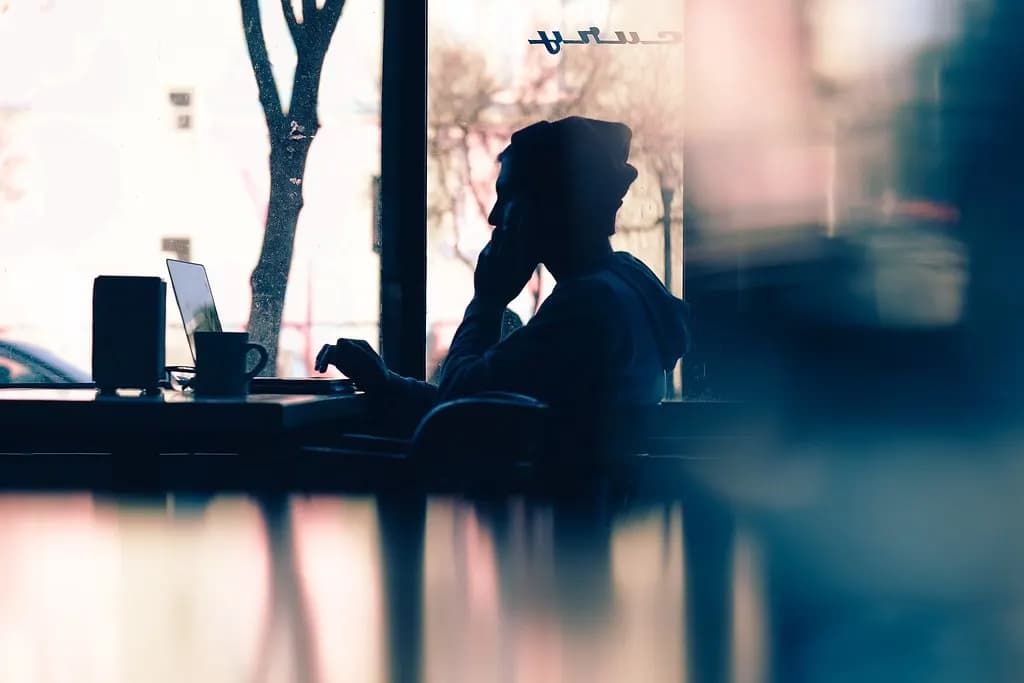A freelancer working on a laptop in a coffee shop