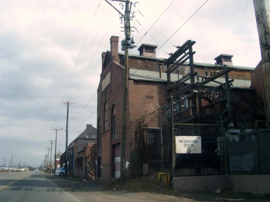 A brick warehouse with a sign marking receiving dock number 5 beside an industrial street