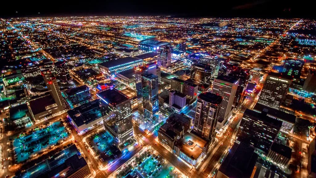 Aerial night view of downtown Phoenix with the city grid lit up to the horizon
