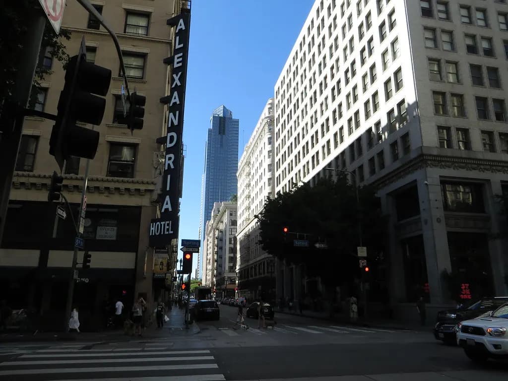 Street corner in the Historic Core of downtown Los Angeles with older commercial buildings and a high-rise behind