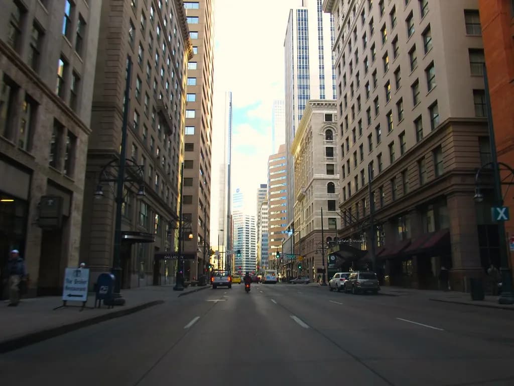 17th Street in downtown Denver, lined with historic stone office buildings and newer towers