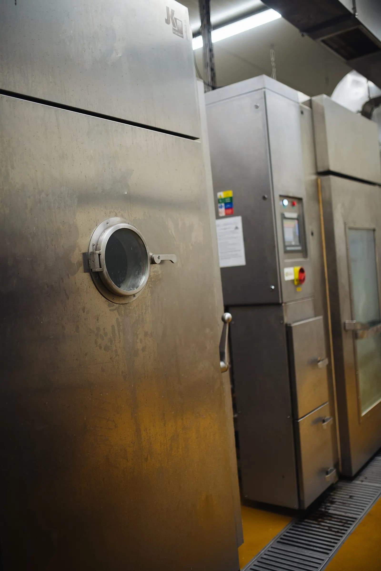 Stainless-steel commercial kitchen cabinets and ovens lined up in a restaurant back-of-house