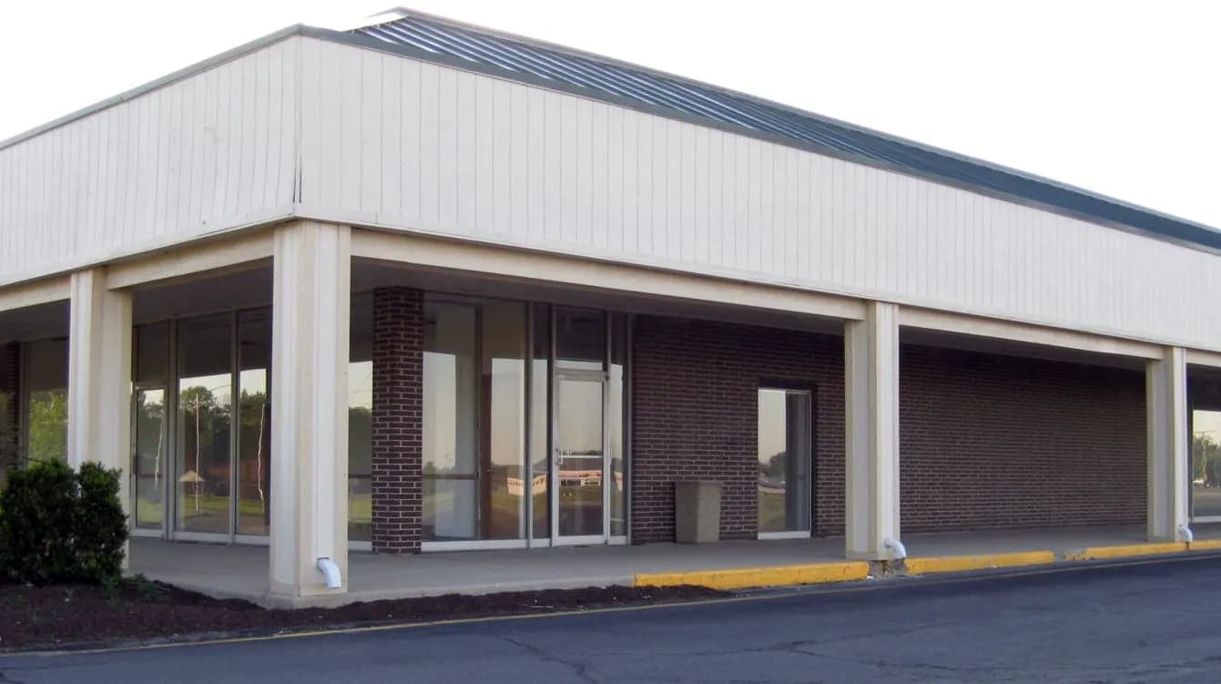 Vacant single-storey strip mall storefront with glass doors and brick walls in Fort Wayne, Indiana