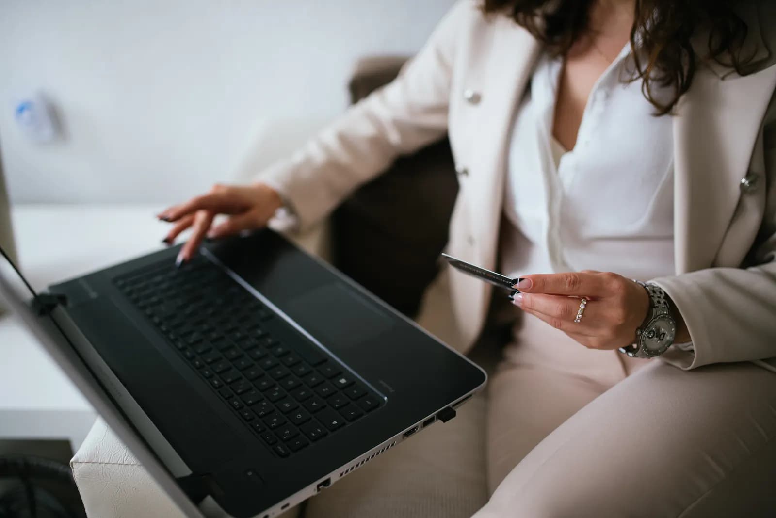 Shopper holding a credit card while typing on a laptop to complete an online order