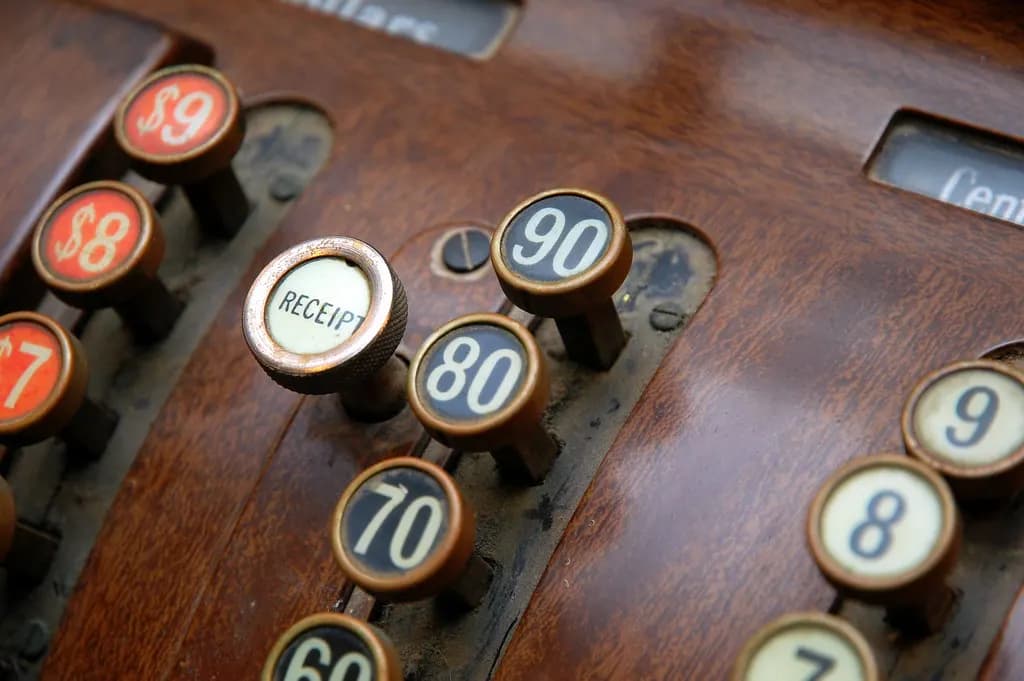 Close-up of brass and enamel keys on a vintage cash register, including a Receipt key