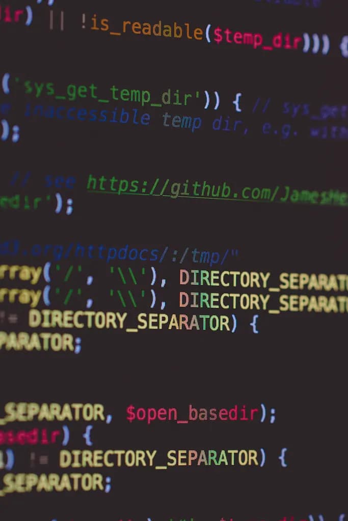 Close-up of colorful HTML, PHP and JavaScript source code on a dark computer screen