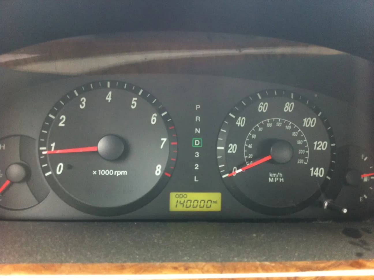 A car dashboard with the odometer reading 140,000 miles