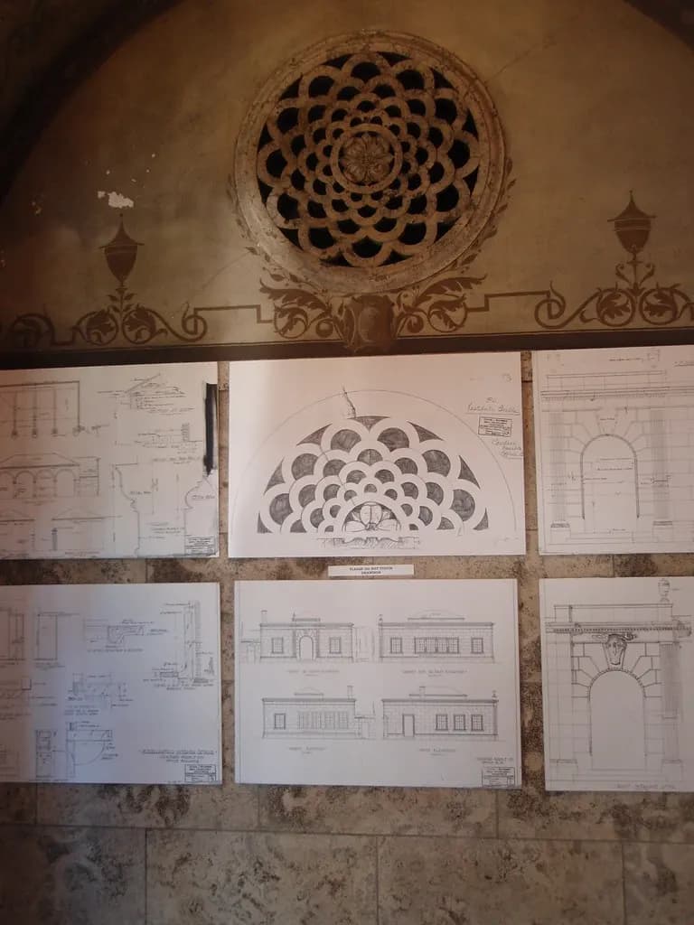 Sheets of architectural plans and elevation drawings pinned to a wall