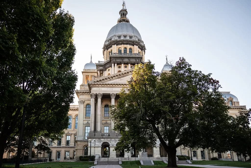 The Illinois State Capitol in Springfield, a domed limestone building, under a clear sky
