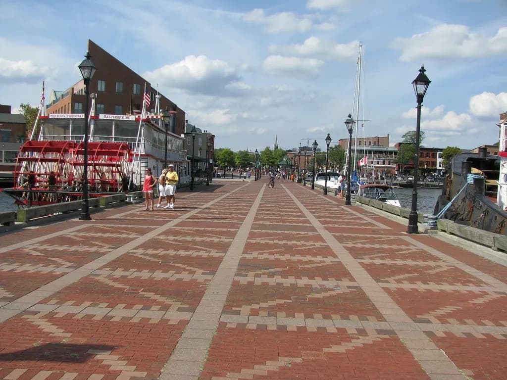 The brick waterfront promenade at Fell's Point in Baltimore, with a paddle-wheel boat moored alongside