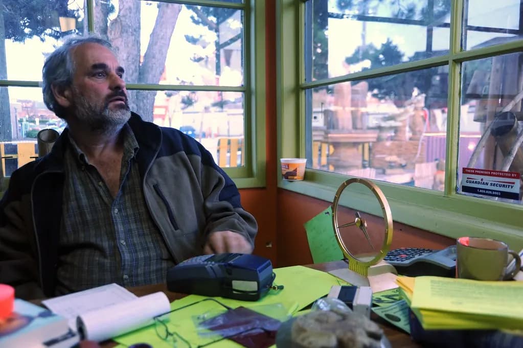 Shop owner at his counter with a card payment terminal and receipt book