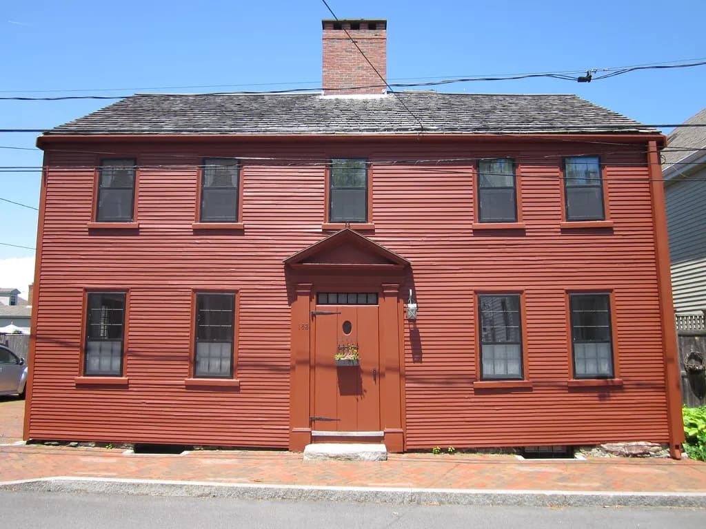 A red clapboard colonial house on a brick sidewalk in Portsmouth, New Hampshire