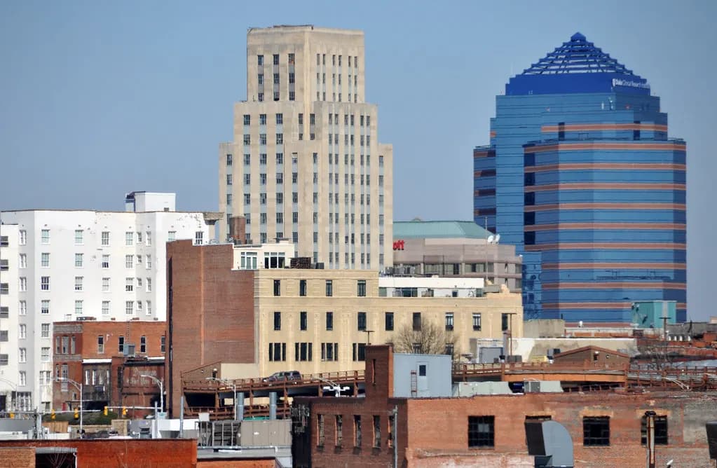 Downtown Durham, North Carolina, with brick commercial buildings in front of an art deco tower and a blue glass office tower