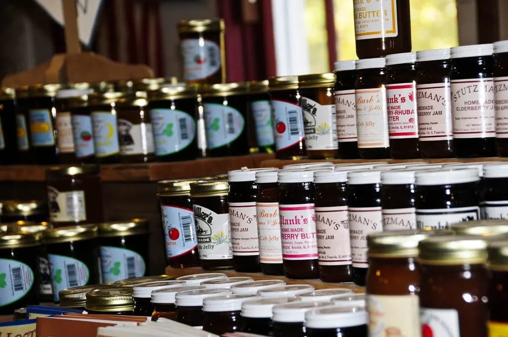 Shelves of homemade jams and jellies in labeled jars at a farm store