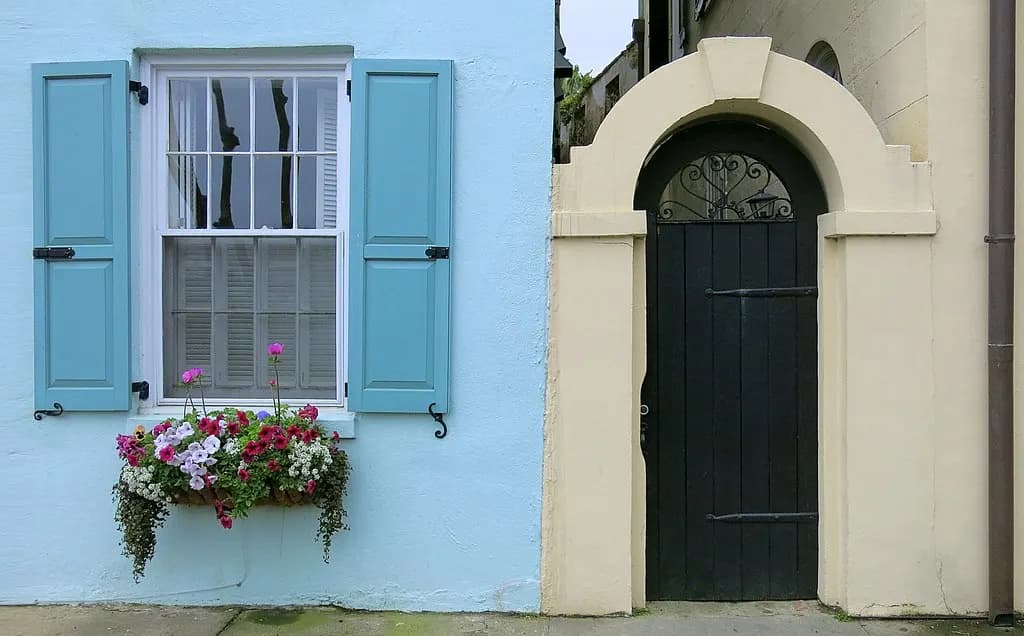 A pastel blue house and an arched gateway on Rainbow Row, East Bay Street, Charleston