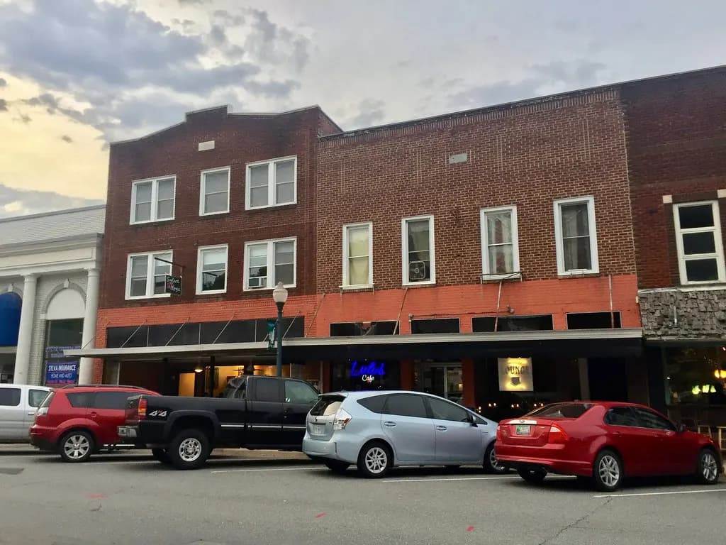 Brick storefront buildings with parked cars on Main Street in Sylva, North Carolina