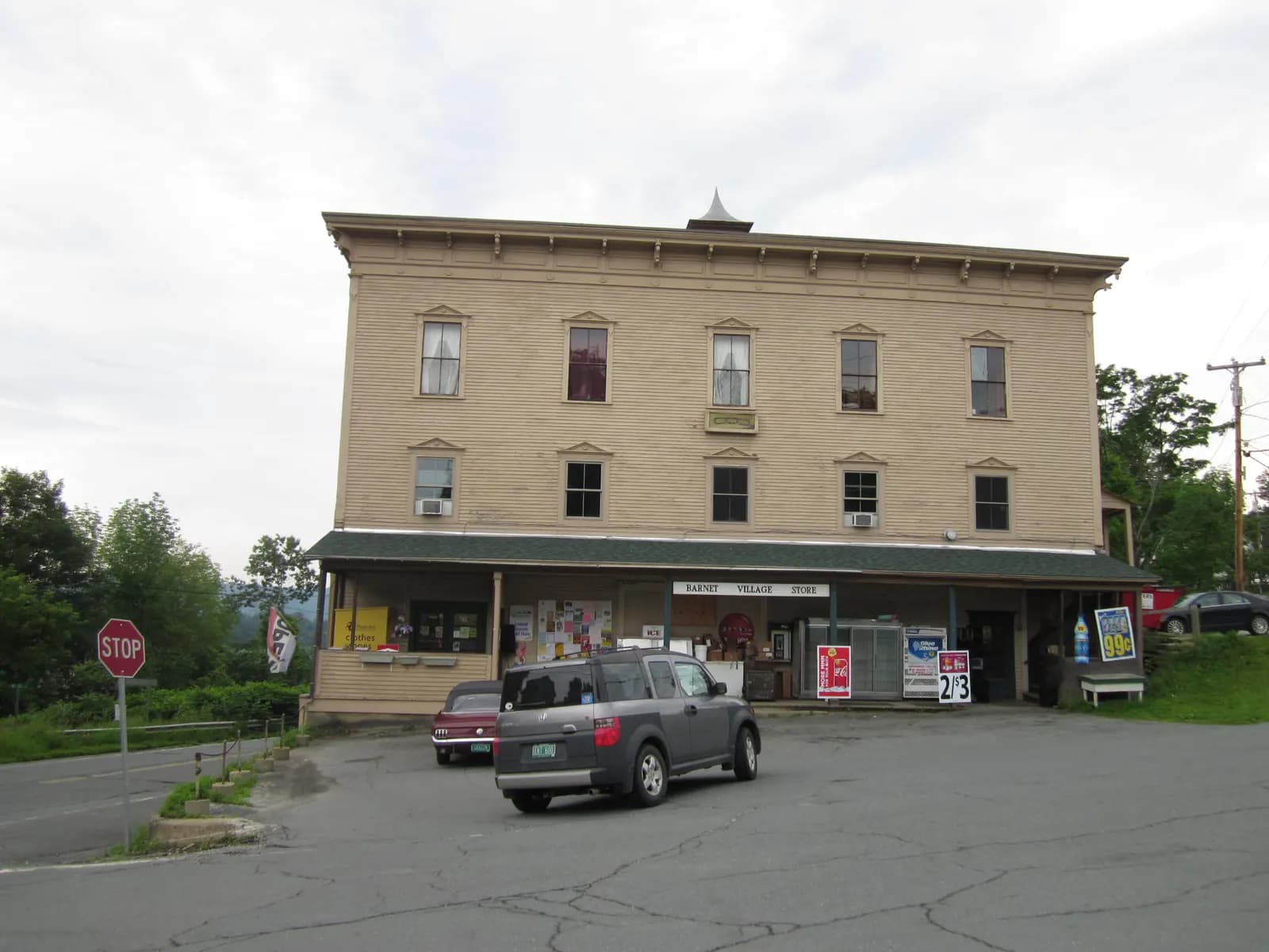 Three-story village store building with a porch and car park in Barnet, Vermont
