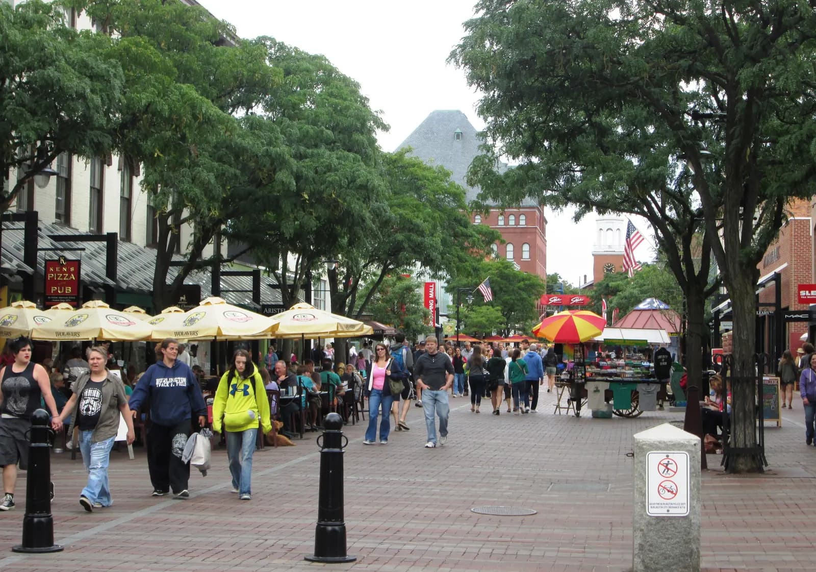 Pedestrian Church Street Marketplace in Burlington, Vermont, with outdoor café umbrellas and shoppers under trees
