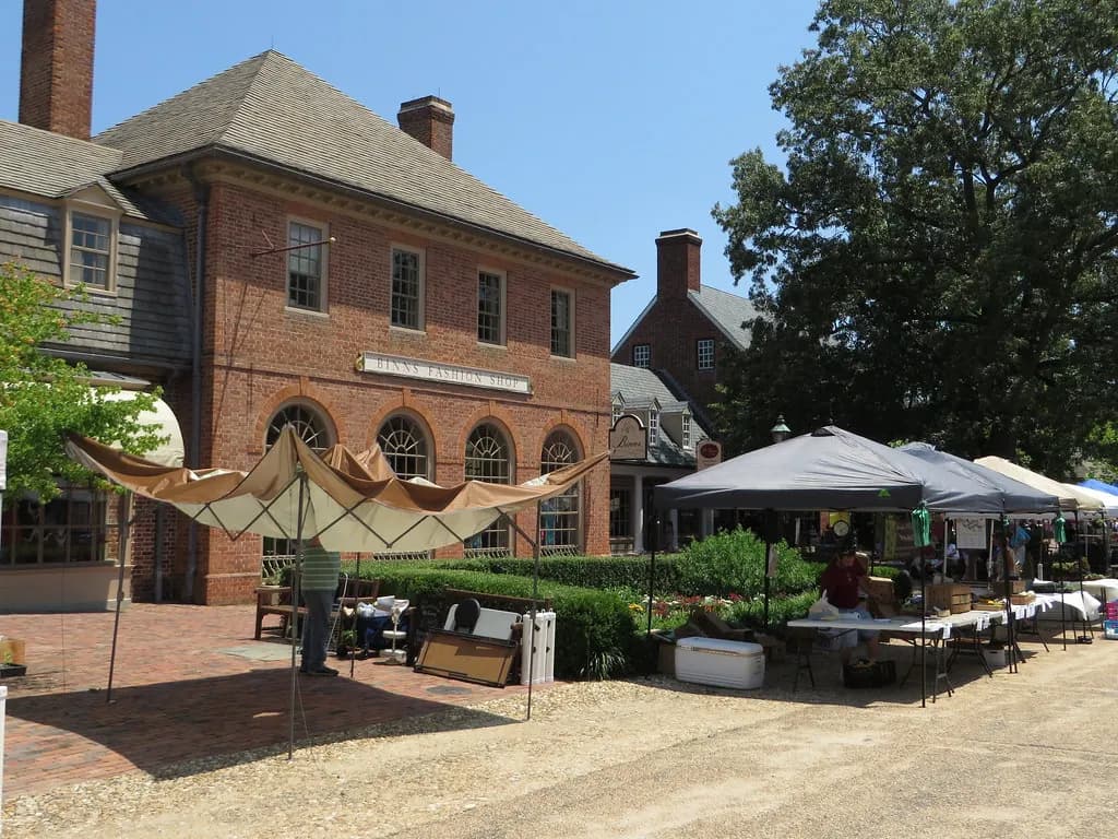 Farmers market tents beside brick shops on Merchants Square in Williamsburg, Virginia