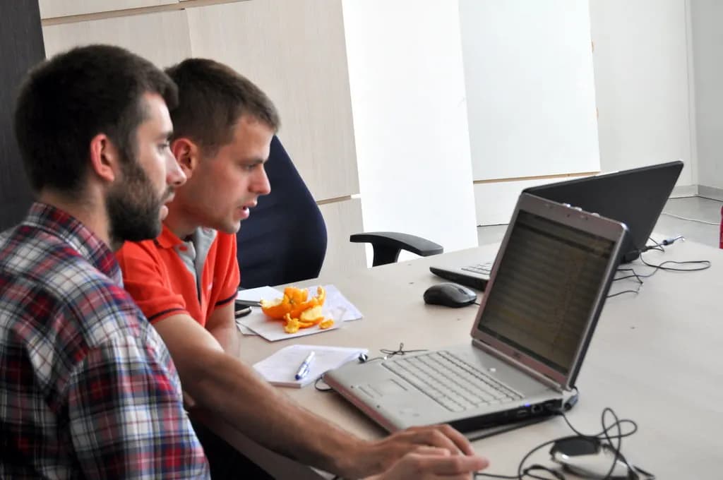 People working on laptops at long shared desks in a coworking space in Vilnius, Lithuania