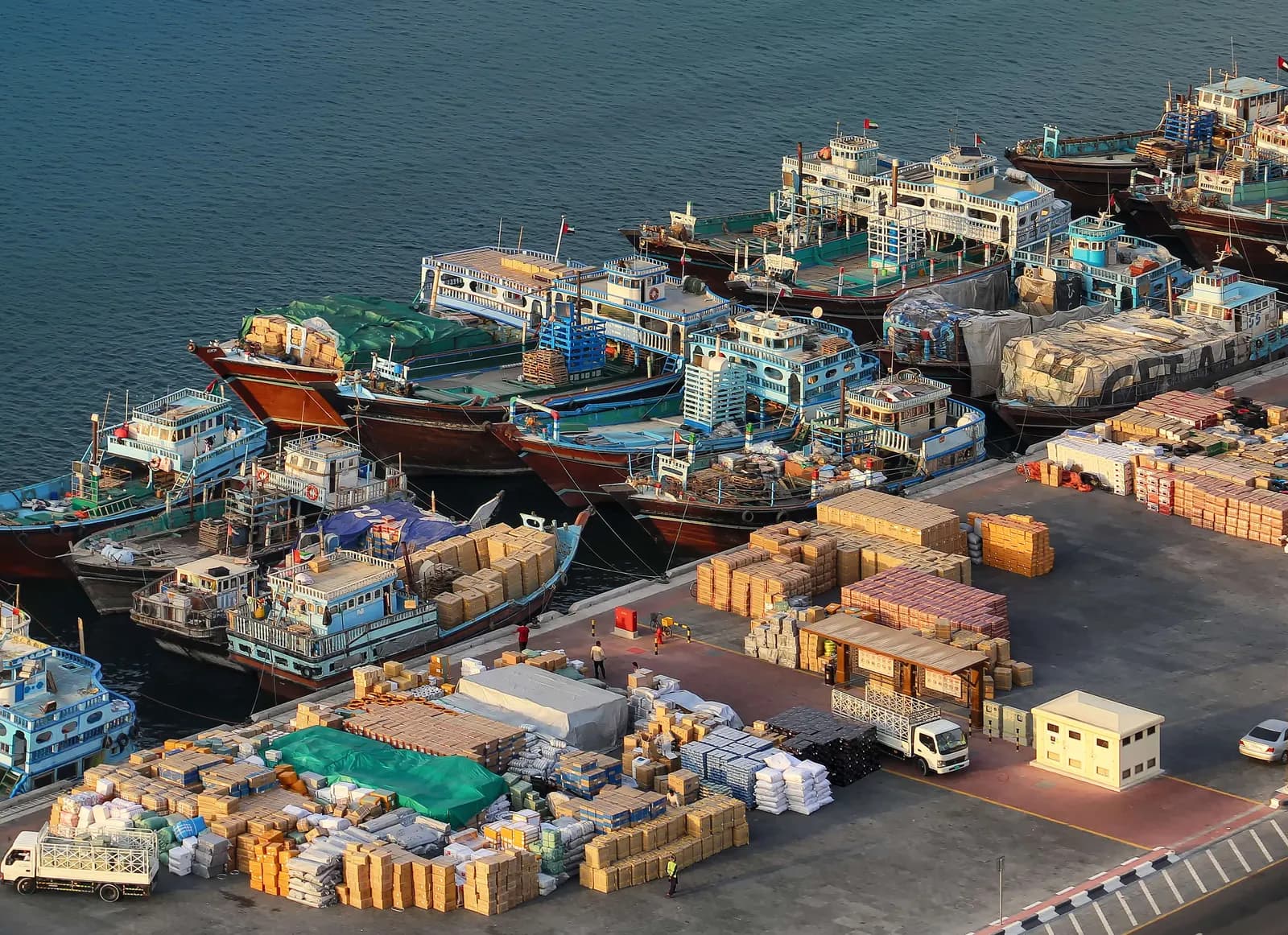 Dhows moored at the Deira wharfage with export cargo stacked on the quay