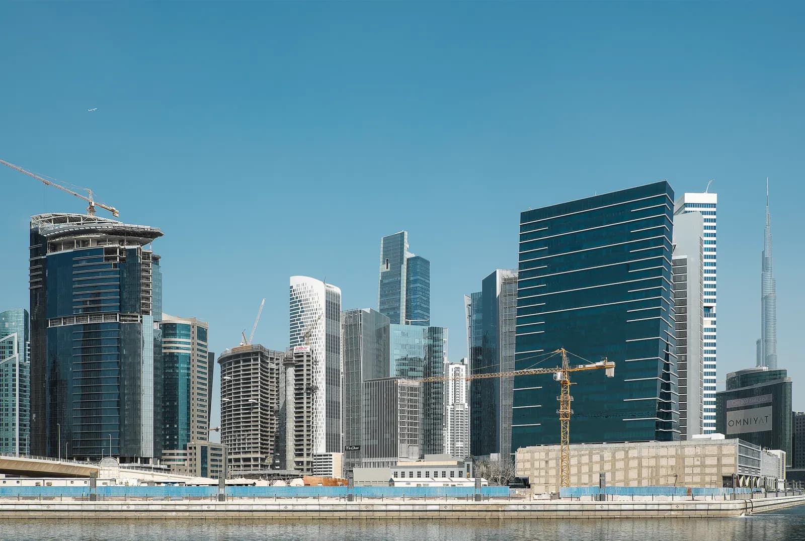 Office towers in Business Bay, Dubai, seen across the water with cranes on new buildings