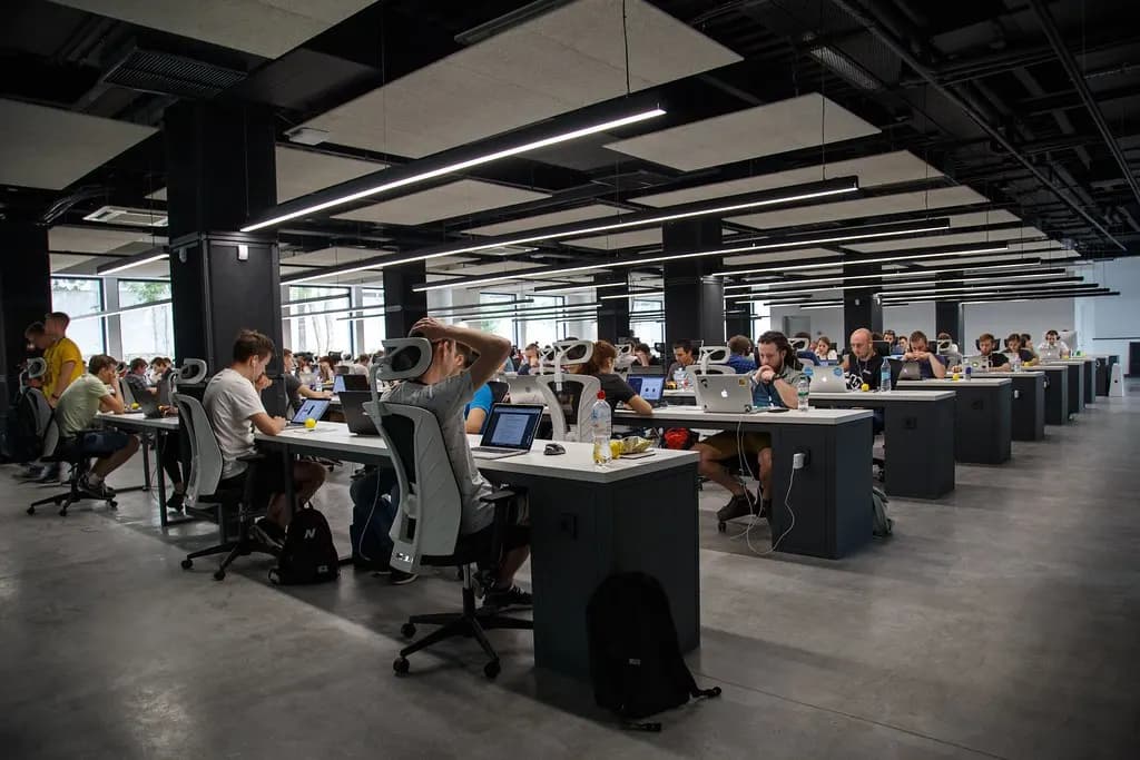 Rows of shared desks in an open-plan coworking office